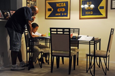 CSM Roger Parker, Jr., (US Army-Ret), helps his grandson Tyrell Parker, 9, whom Parker is raising, work on his homework at their apartment on September 12, 2011 in Pasadena, Md. Parker, 51, has returned to college to study Health, Fitness and Nutrition at Anne Arundel Community College. Colleges such as Anne Arundel Community College in Maryland have opened up the Military and Veterans Resource Center to assist military personnel and veterans returning to school while and after serving in the armed forces. (Photo by Ricky Carioti/The Washington Post)